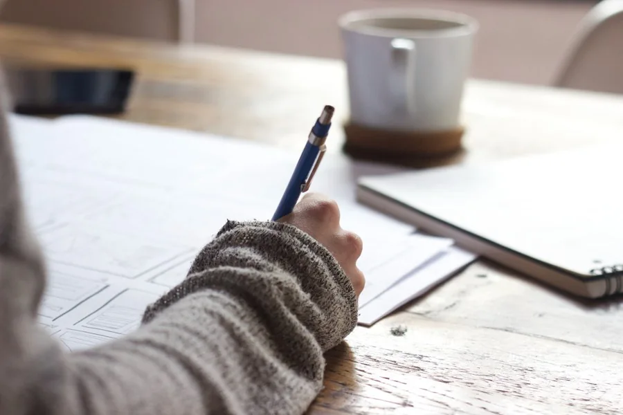 Une personne prend des notes pour avancer sur son projet